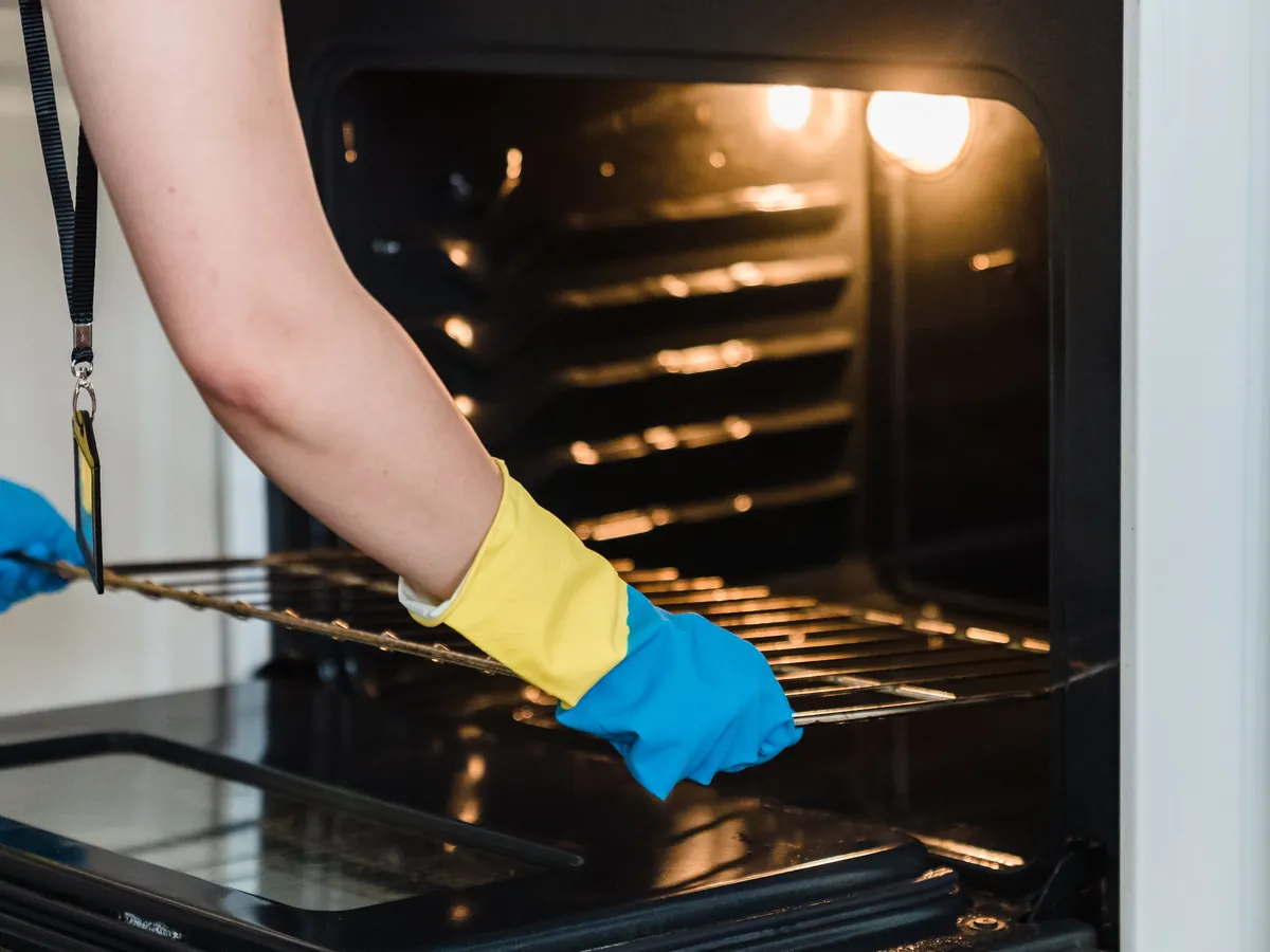 Cleaning the inside of an oven with rubber gloves