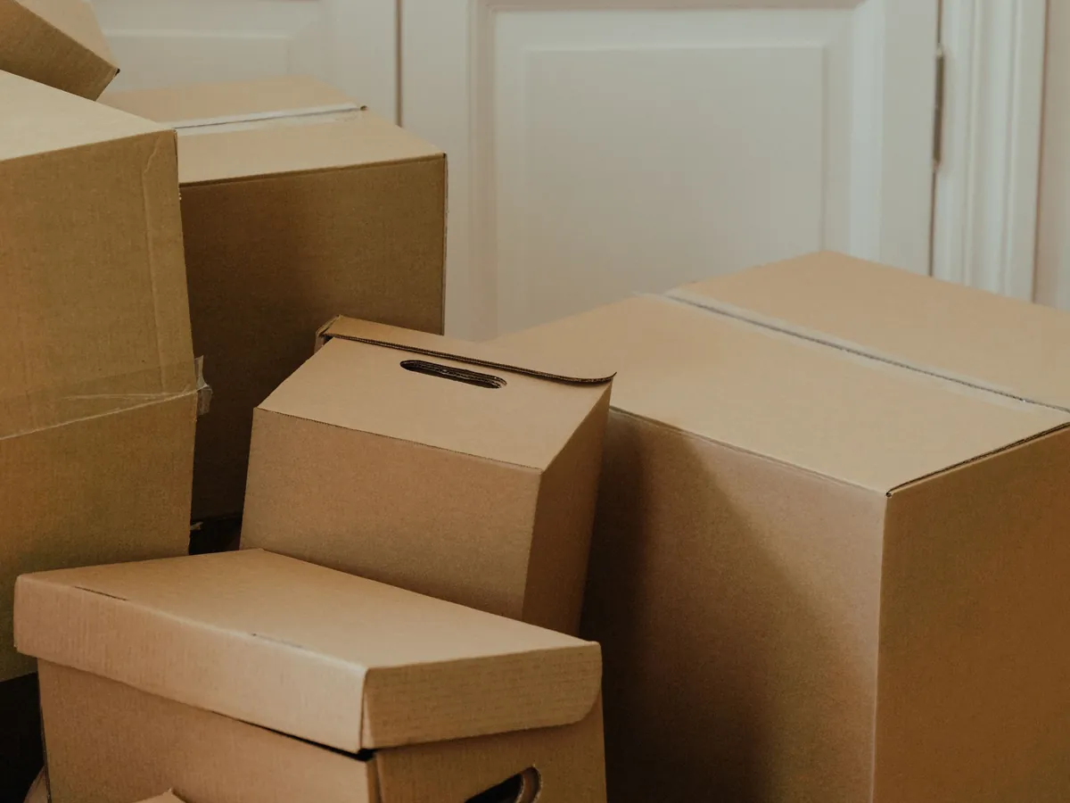 Moving boxes stacked by the door of a bright home