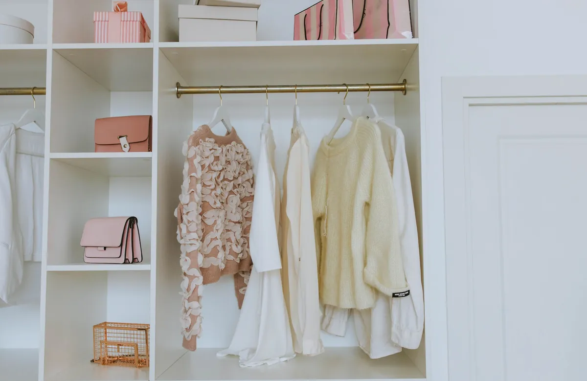 A tidy closet with folded items and neatly hung clothes